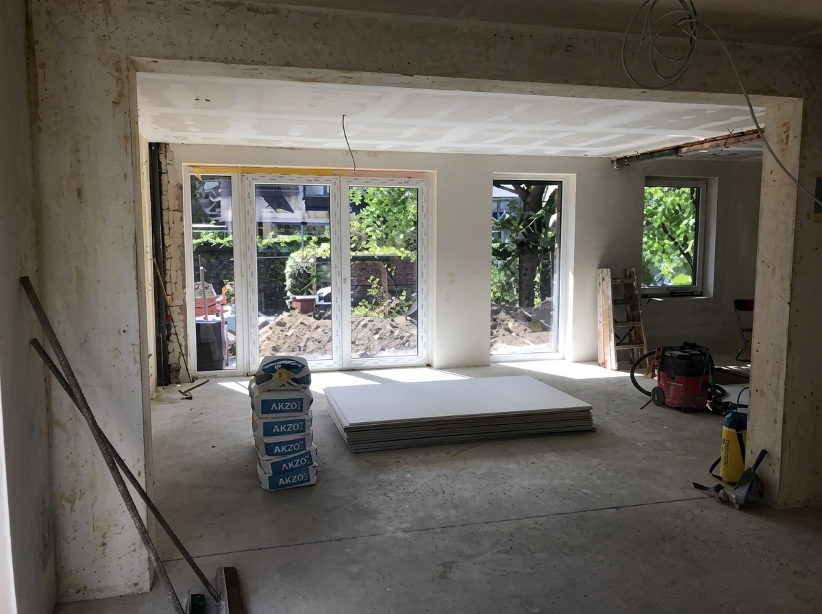 Geöffneter Wohnbereich nach der Sanierung mit neuer Fensterfront und Tageslicht