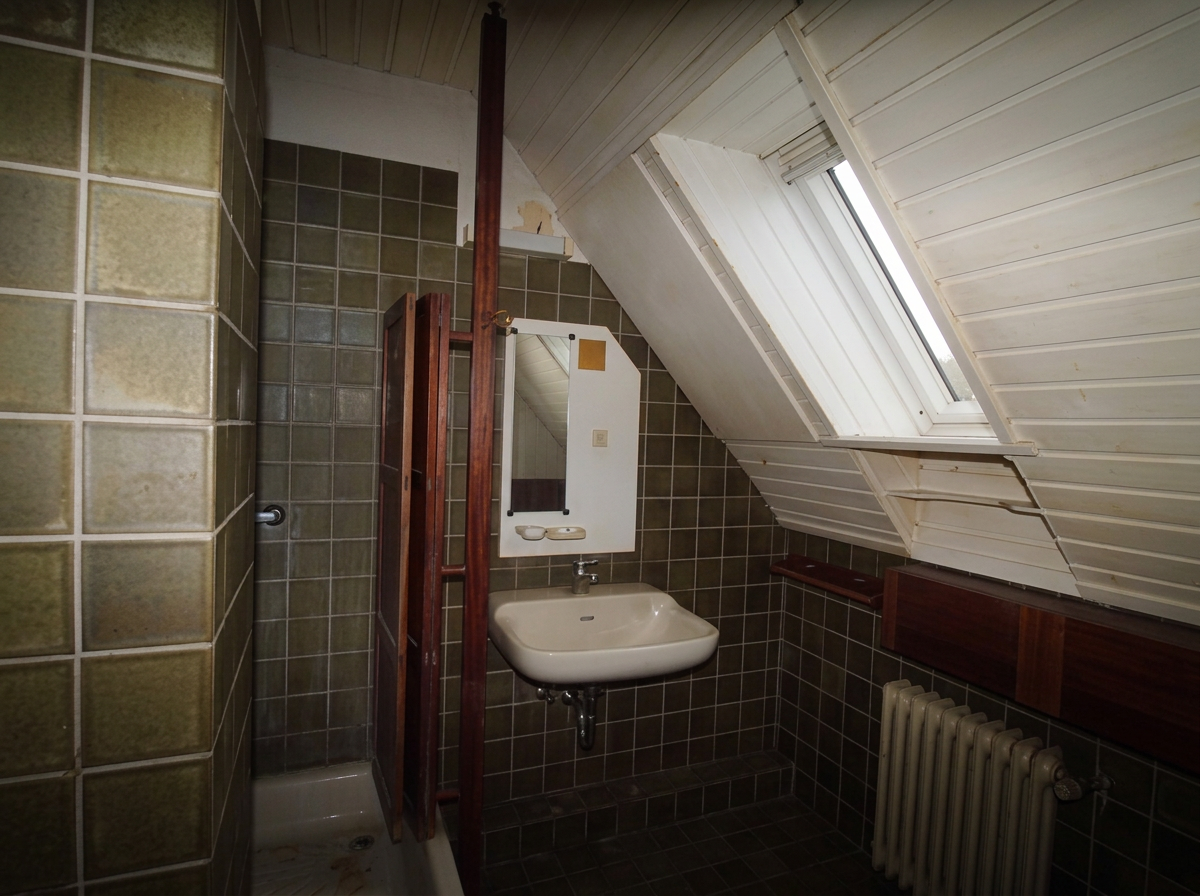 Altes dunkles Dachgeschossbad mit Dachschräge vor der Sanierung