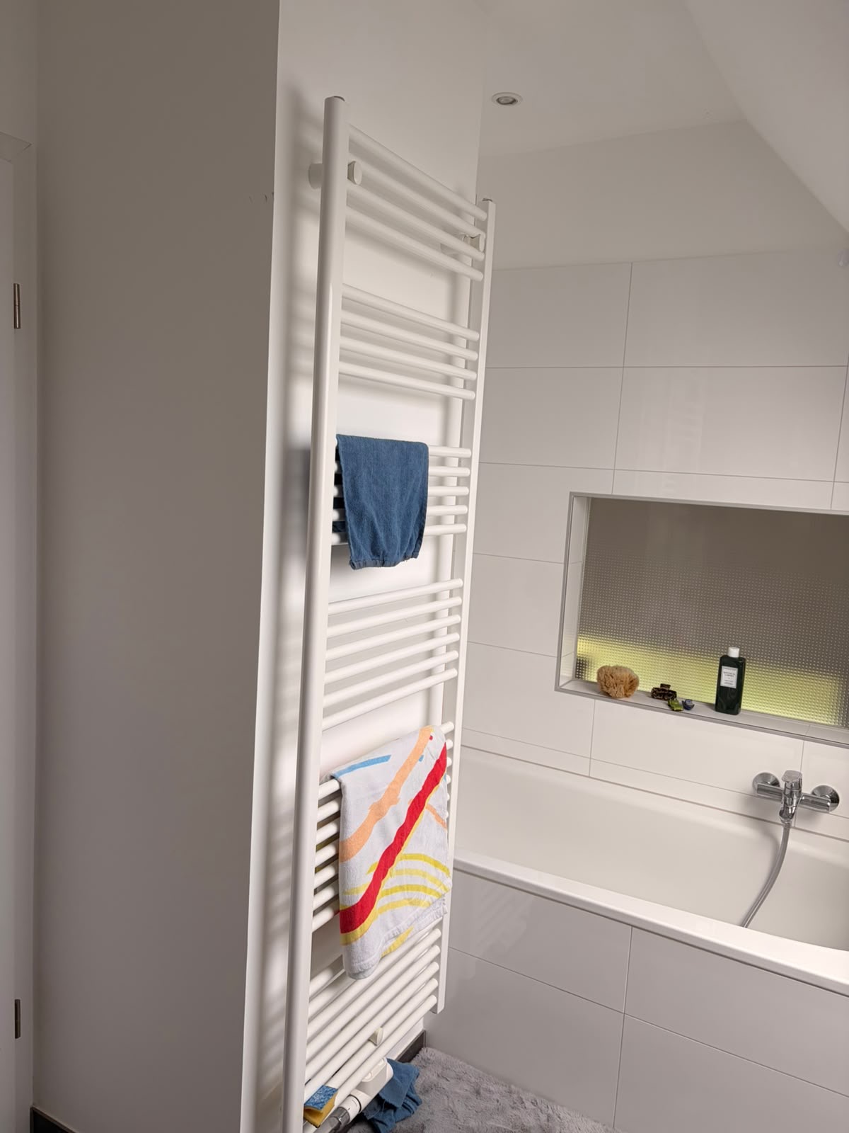 Modernes Dachgeschossbad mit Badewanne, Handtuchheizkörper und beleuchteter Nische